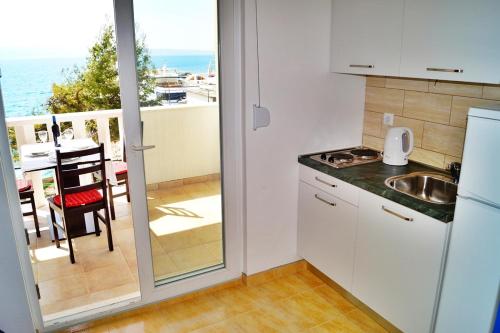 eine Küche mit Blick auf den Balkon mit Meerblick in der Unterkunft Marinero Studio Apartments in Split