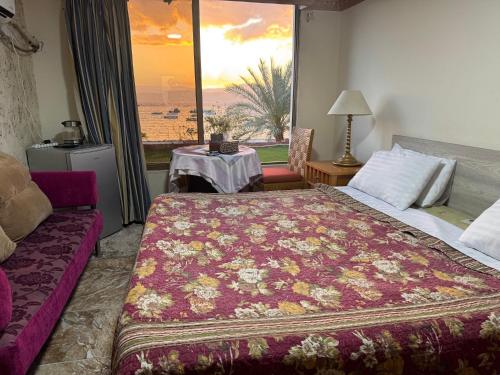 a hotel room with a bed and a large window at Al-Amer Aqaba Beach Hostel in Aqaba