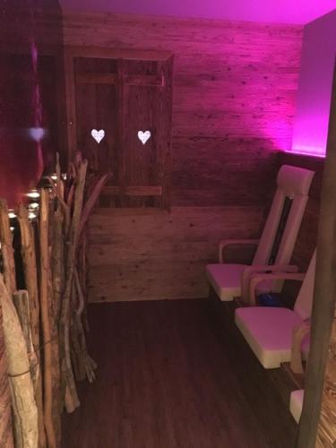 a room with two chairs and purple lights at Chasa Castello relax & spa in Samnaun