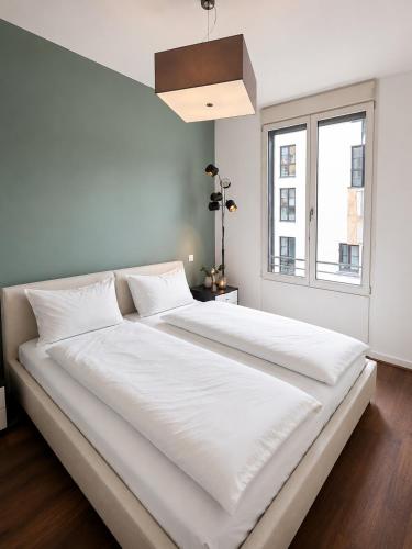 a large white bed in a room with a window at Marienplatz Design Apartment - Historic Center in Munich