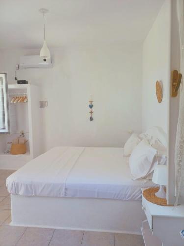 a white bedroom with a white bed in a room at Georgia Rooms Milos in Plaka Milou