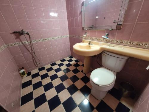 a pink bathroom with a sink and a toilet at Shine Motel in Busan