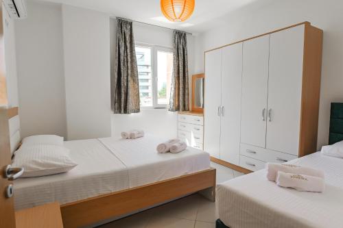a bedroom with two beds and a dresser at Hotel Maresol Accommodation in Shëngjin