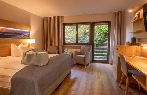 a hotel room with a bed and a desk at Hotel Die Kleine Blume in Erfweiler