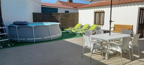 a patio with a table and chairs and a hot tub at Murta's Home in Cadaval