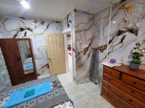 a bedroom with a wall with a mural of a tree at Dream Big Accommodation in Apia