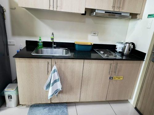 a kitchen with a sink and a counter top at De Luxe, Standard and Studio Suites -The Breeze Residences-close to Airport,Mall of Asia, US Embassy in Manila