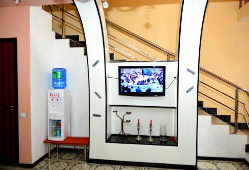 Carat Hotel في طشقند: جدار مع تلفزيون في غرفة مع درج