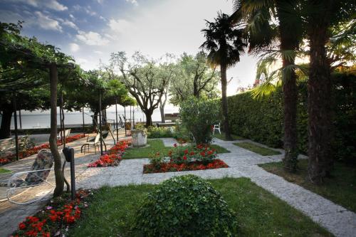 a garden with flowers and palm trees in a park at Hotel Giardino in Sirmione