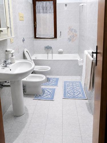 a bathroom with a sink and a toilet and a tub at Vista Isole Eolie in Piraino