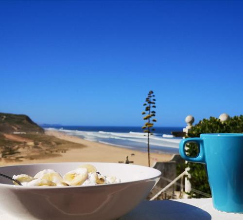 a bowl of food sitting on a table next to a beach at Neptune Beach House in Lourinhã