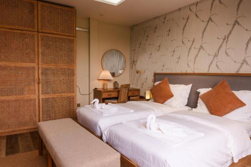 two beds in a hotel room with white sheets at Island Ufaa Dharavandhoo in Dharavandhoo