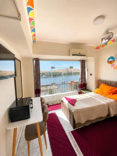 a bedroom with a bed and a view of the water at NubaNest GuestHouse in Aswan
