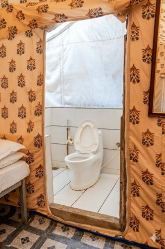 a bathroom with a toilet in a tent at Vanveli The Forest Resort in Sasan Gir