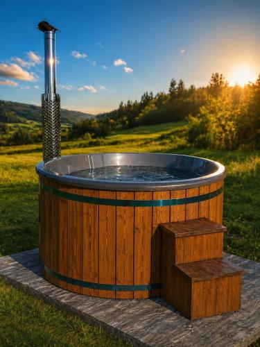a wooden hot tub in the middle of a field at Domki w Zielonym Gaju in Ustrzyki Dolne
