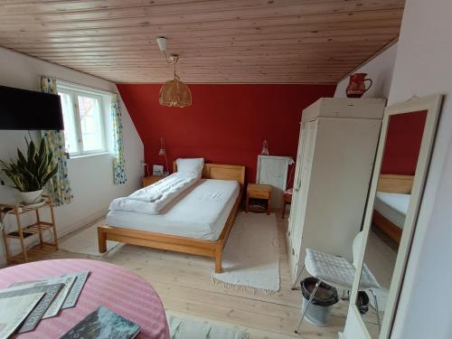 a bedroom with a bed and a red wall at Aakirkeby Bed and Breakfast in Åkirkeby