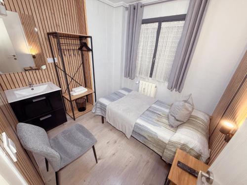 a small bedroom with a bed and a sink at PENSIÓN PESQUERO in Burgos