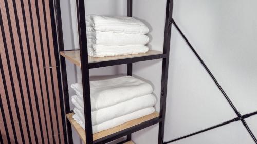 a black towel rack with white towels on it at PENSIÓN PESQUERO in Burgos