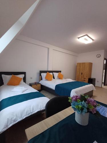 a hotel room with two beds with orange and blue at Aqua Sia in Sighetu Marmaţiei