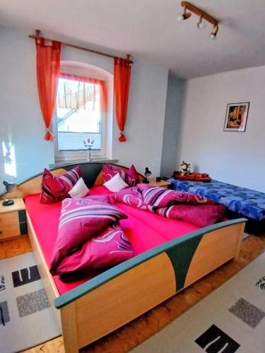 a bedroom with a large bed with a red blanket at Ferienwohnung-Heidi in Neuwilthen