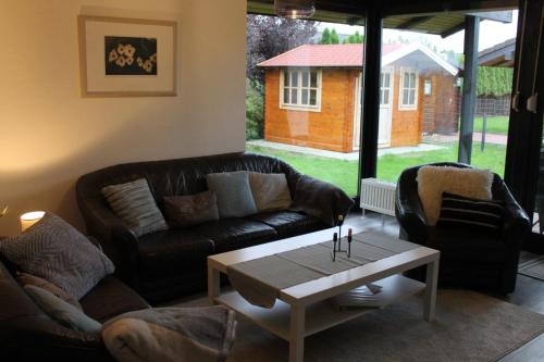 a living room with a leather couch and a coffee table at Haus am Meer Eckwarden in Butjadingen