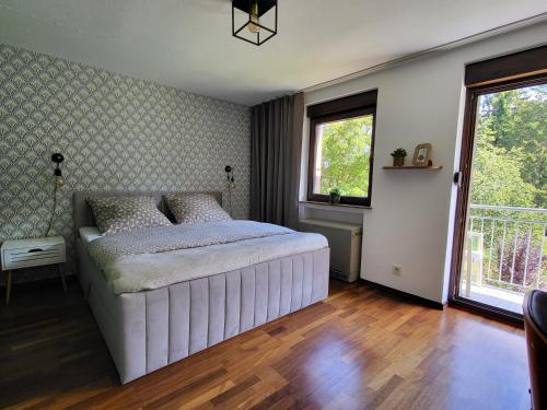 a bedroom with a large white bed and a window at Ferienwohnung Tutbach in Jünkerath