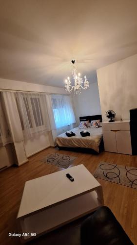 a living room with a bed and a chandelier at Spalentor City Apartement in Basel