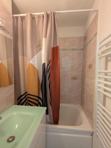 a bathroom with a tub and a shower curtain at Les Portes du Soleil Studio in Le Biot
