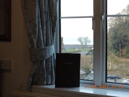 a window with a book sitting on a window sill at Orchard House Hotel in Lynmouth
