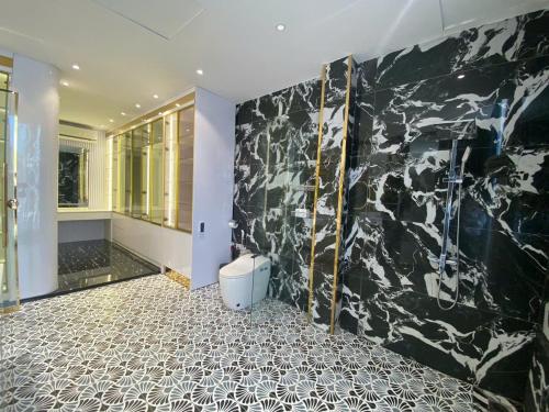 a bathroom with a black and white marble wall at VMona Hotel in Thôn Kim Long (1)