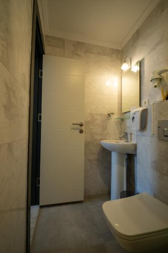 a bathroom with a toilet and a sink at Artemis Hotel in Bodrum City