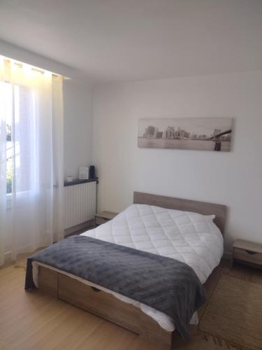 a bedroom with a large bed with white sheets at Maison à Macon in Mâcon