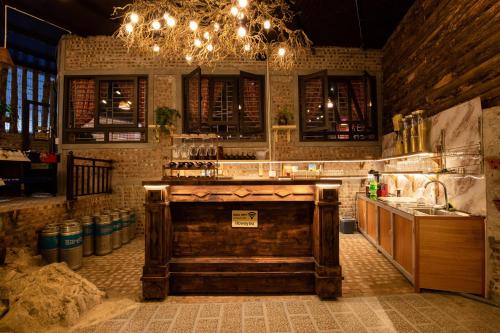 a kitchen with a bar with a sink and lights at Tada Moc Chau - Villa & Local Kitchen in Mộc Châu