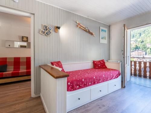 a bedroom with a bed with red sheets and a window at Appartement au cœur de La Clusaz, animaux acceptés - FR-1-304-7 in La Clusaz
