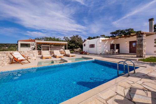 a villa with a swimming pool and a house at Minos Villa in Arménoi