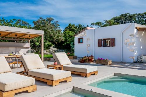 a patio with chairs and a swimming pool at Minos Villa in Arménoi