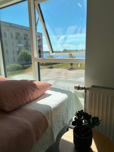a bedroom with a bed and a view of the ocean at South Harbour Studios in Vordingborg