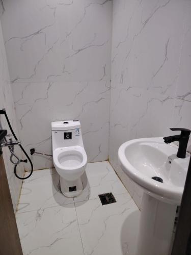 a white bathroom with a toilet and a sink at استديو داخل بناية حي النرجس in Riyadh