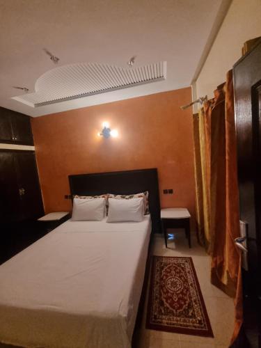 a bedroom with a large bed with white sheets at Appartement sselam fetouaki montagne view in Moulay Yacoub