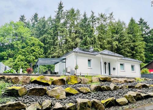 a white house with trees in the background at Ferienhaus Waldblick in Hohenfels-Essingen
