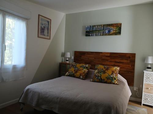 a bedroom with a bed with two pillows and a window at Maison indépendante à la campagne proche centre urbain in Muret