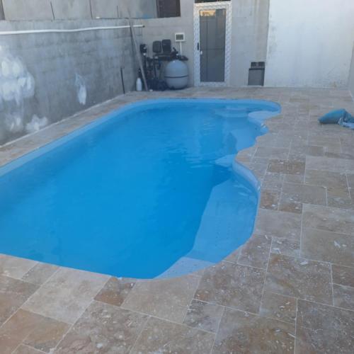 a swimming pool with blue water in a patio at Ti nae in Étang-Salé