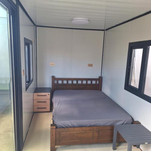 a bedroom with a bed and a table and a window at Ti nae in Étang-Salé
