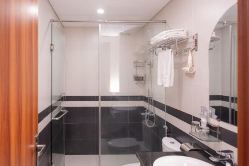 a bathroom with a glass shower and a sink at Hummer Hotel & Apartment Da Nang Beach in Danang