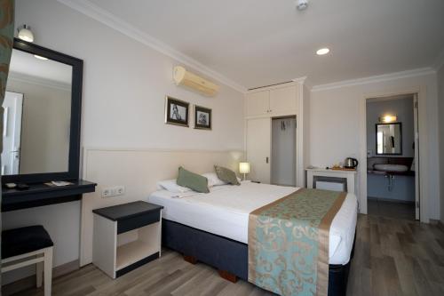 a hotel room with a bed and a bathroom at Artemis Hotel in Bodrum City