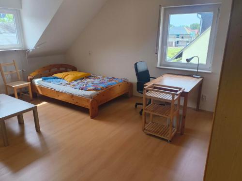a bedroom with a bed and a desk and a table at Inselappartement in Niederwerth
