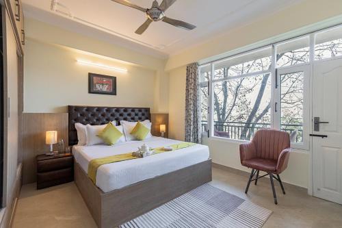 a bedroom with a bed and a chair and a window at The Walnut Stays in Solan
