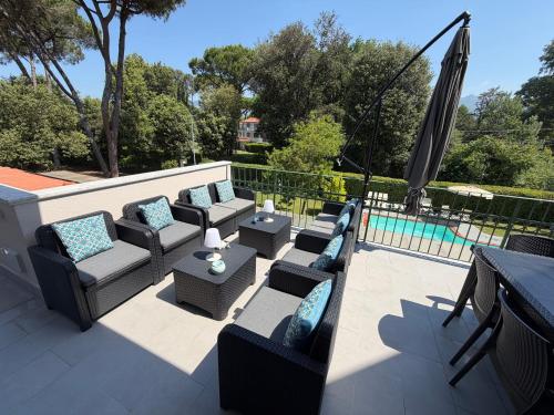 a patio with couches and chairs next to a pool at Lightblue in Marina di Massa