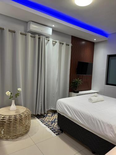 a bedroom with a large bed and a tv at Deluxe Nest - Windhoek in Windhoek
