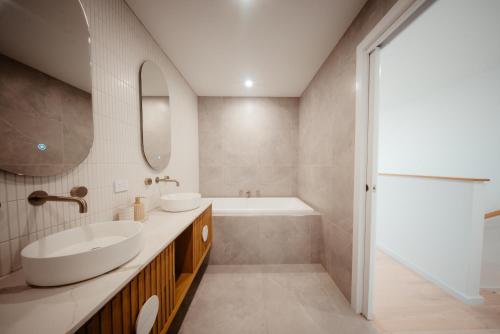 a bathroom with two sinks and a tub and a tubermottermott at Coastal on Clarke in Portarlington